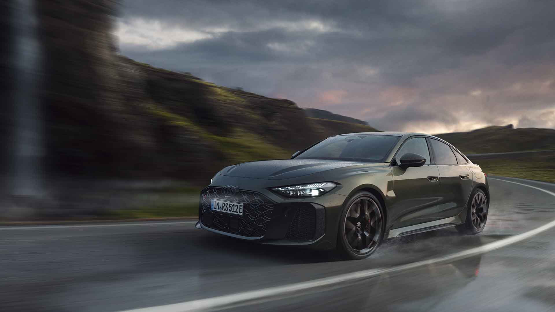 Audi RS 5 Limousine, grün, Front-Seitenansicht fahrend auf einer regennassen Straße