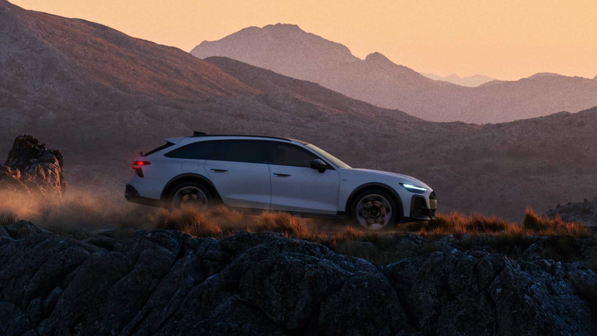 Audi A6 allroad e-hybrid, weiß, Seitenansicht, fahrend auf unbefestigter Straße